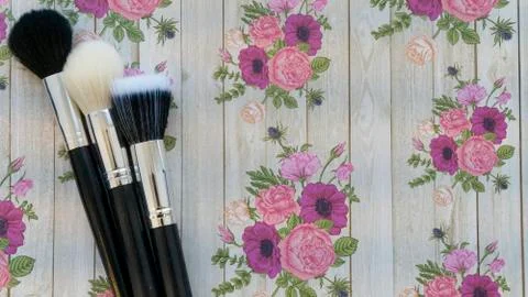 Makeup brushes on a floral background Stock Photos