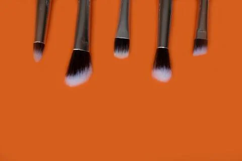 Makeup brushes on orange background.Copy space Stock Photos