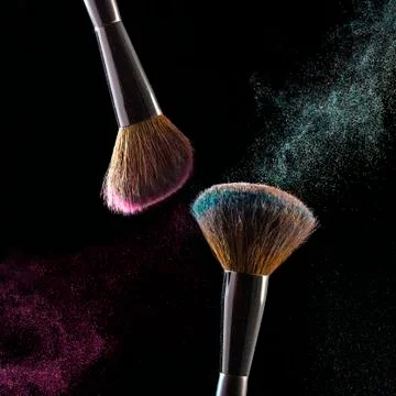 Makeup brushes, powder particles dynamically in the air. Spray cosmetics. Fro Stock Photos
