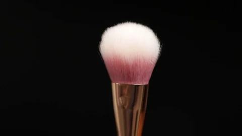 Makeup brushes rotate on a black background. Stock Footage 127614130