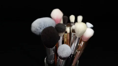 Makeup brushes rotate on a black background. Stock Footage 127614131