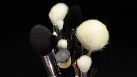 Makeup brushes rotate on a black background. Stock Footage 127614161