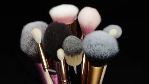 Makeup brushes rotate on a black background. Stock Footage 127614183