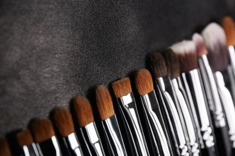 Makeup brushes set on black leather background Stock Photos