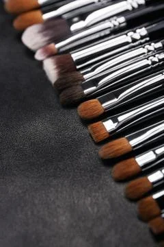 Makeup brushes set on black leather background Stock Photos