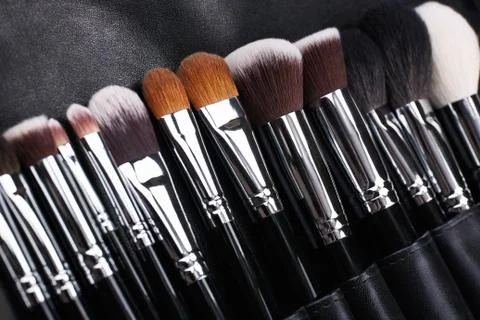 Makeup brushes set on black leather background Stock Photos