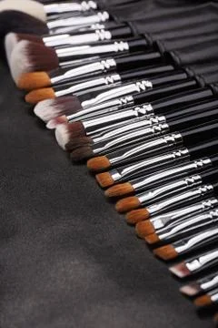 Makeup brushes set on black leather background Stock Photos