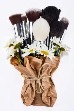 Makeup brushes set packed in paper with chamomiles Stock Photos
