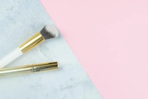 Makeup brushes stand on a concrete background that stands on a pink table Stock Photos
