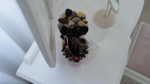 Makeup brushes standing on a vanity table Stock Footage 345878475