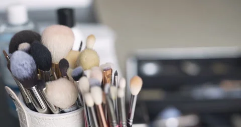 Makeup brushes standing in a white cup on a vanity table Stock Footage 336470830