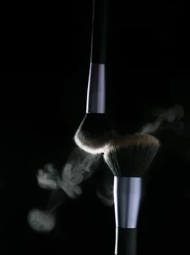 Makeup brushes' touch on black background Fotos Stock