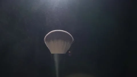 Makeup brushes touch each other on dark background and small particles of Stock Footage 150053819