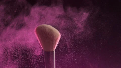 Makeup brushes touch each other on dark background and small particles of Stock Footage 194395666