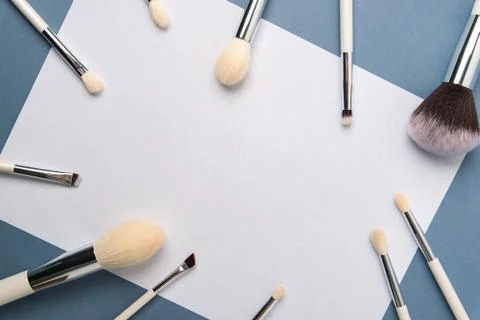 Makeup brushes with a white handle on a blue background Stock Photos