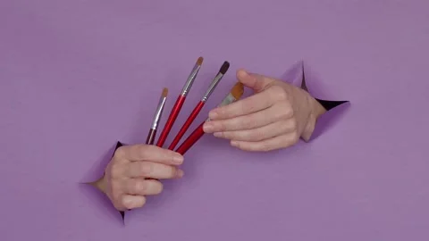 Makeup brushes in your hands on a purple background Stock Footage 152731365