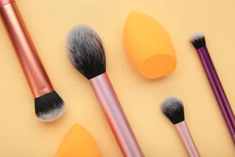 Makeup buffer brush and beauty makeup sponges on beige background. Beauty and Stock Photos