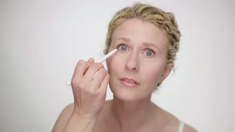 Makeup Demonstration: Blonde curly haired woman applies eyeliner slow motion 스톡 동영상 193839527