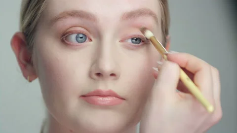 Makeup demonstration: ￼Closeup side angle woman applies eyeshadow repeatedly Stock Footage 193950190