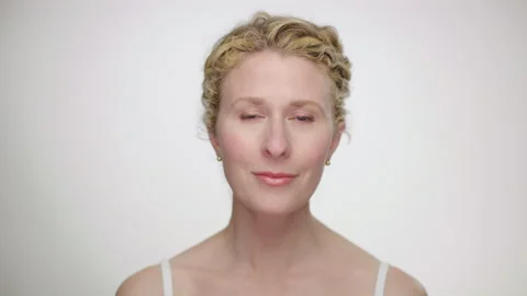 Makeup Demonstration: Pretty blonde model subtly admires makeup in mirror Video stock 193838076