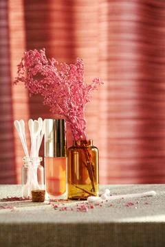 Makeup desk with shiny lip gloss, cosmetic jars and decorative flowers Stock Photos