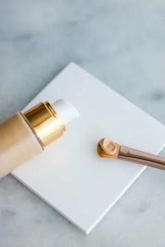 Makeup foundation bottle and contouring brush on marble, make-up concealer bb Stock Photos