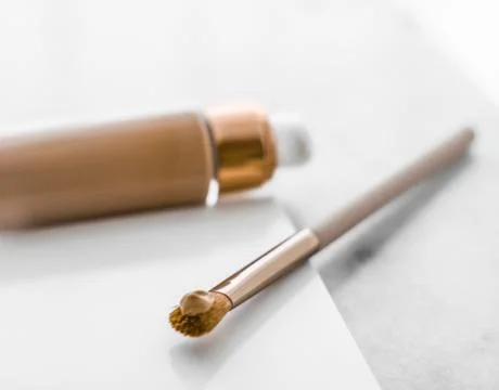 Makeup foundation bottle and contouring brush on marble, make-up concealer bb Stock Photos