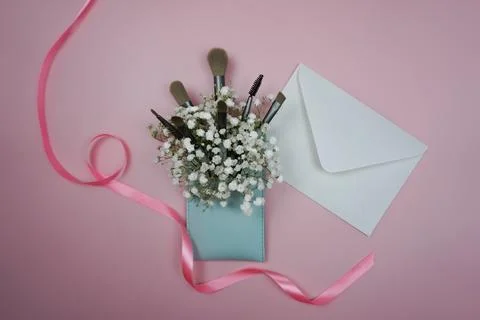 Makeup items are laid out on a pink background Stock Photos