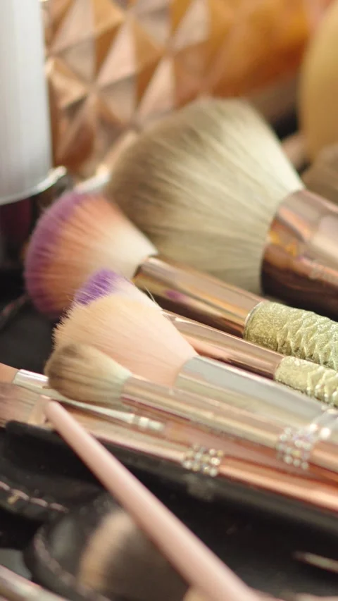 A makeup kit with a gold case and many brushes of different sizes Stock Footage 270081291