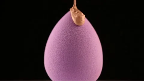 Makeup liquid foundation pouring on make-up blender sponge, closeup. Foundation  動画素材 165624338