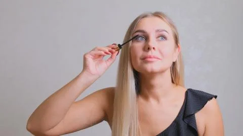 Makeup. Make-Up. Applying Mascara. Long Eyelashes. Woman applying eye mascara to Stock Photos