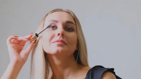 Makeup. Make-Up. Applying Mascara. Long Eyelashes. Woman applying eye mascara to Stock Photos