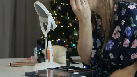 Makeup making process. Young woman in the interior of Christmas, does makeup Vídeo Stock 145726276