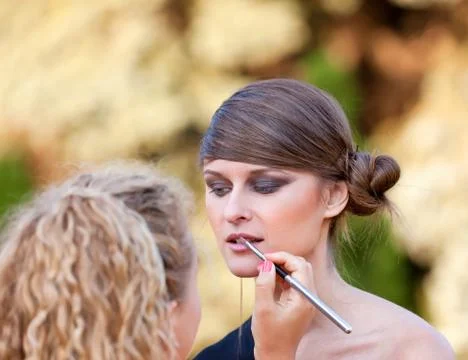 Makeup master applying lipstick Stock Photos