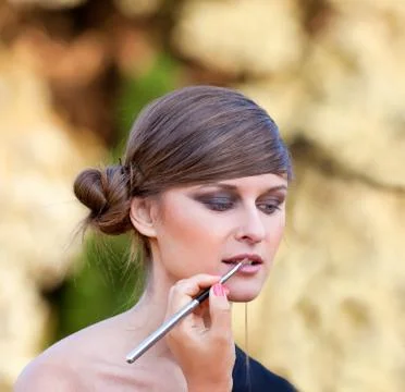 Makeup master applying lipstick Stock Photos