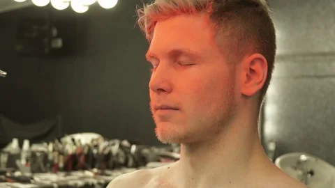 Makeup master covering the model's face with orange color slow motions Stock Footage 73519024