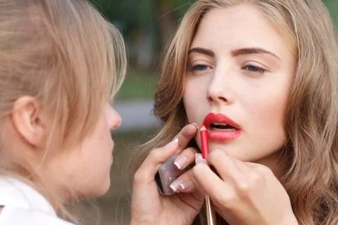 Makeup master paint a beautiful young girl closeup Stock Photos
