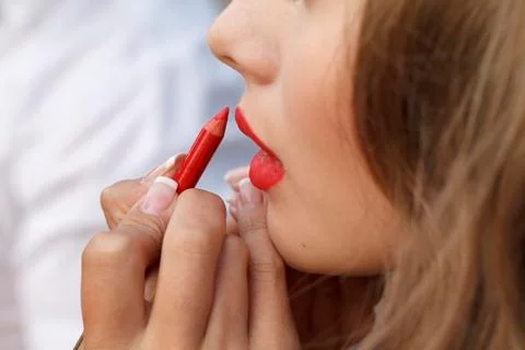 Makeup master paint a beautiful young girl closeup Stock Photos