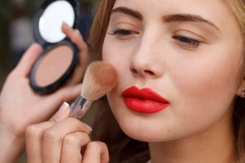 Makeup master paint a beautiful young girl closeup Stock-Fotos
