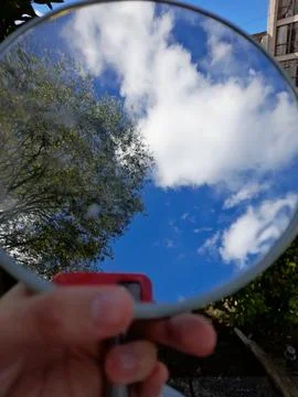 Makeup mirror reflecting the sky and its clouds Stock Photos