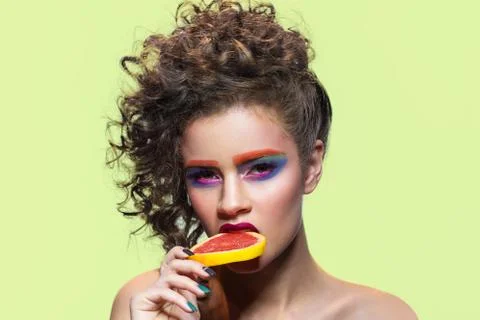 Makeup model biting grapefruit slice. Stock Photos