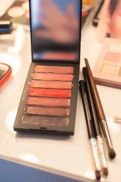 Makeup palette and brushes on table Stock Photos