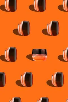 Makeup pattern face cream tonal foundation glass jar geometrical podium orang Stock Photos