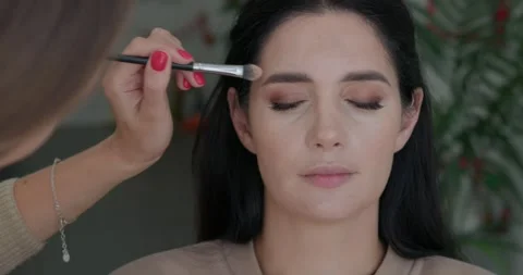 Makeup process: face contouring by a makeup artist for a beautiful girl. Stockbeeldmateriaal 324819858