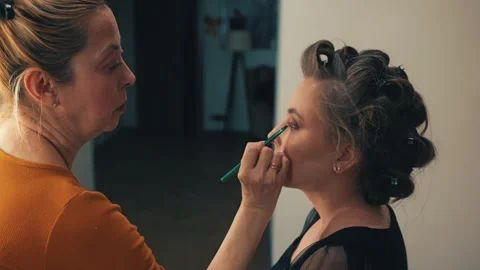 The makeup process includes applying foundation, blush, and lipstick Stock Footage 309049940