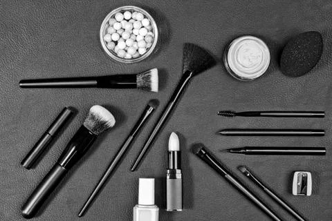 Makeup products and tools with different brushes on black background. Stock Photos