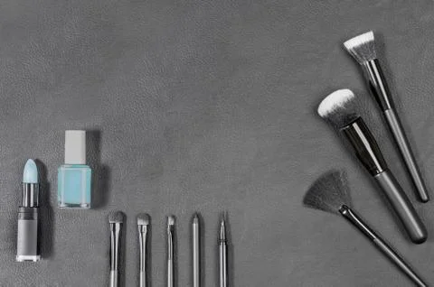 Makeup products with different brushes on black background Stock Photos