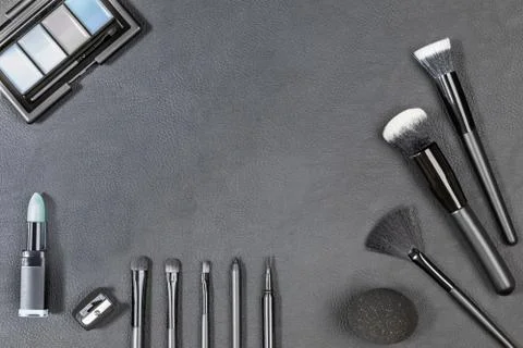 Makeup products with different brushes on black background Stock Photos