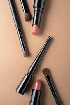 Makeup Products Flat Lay with Brushes Lipsticks and Pencil on Neutral Backgro 库存照片