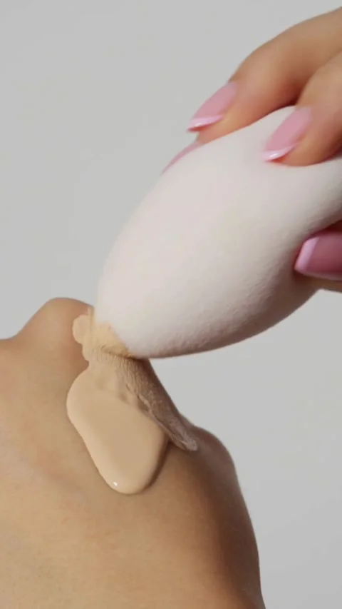 Makeup sponge blends liquid foundation on a person's hand 스톡 동영상 331769848